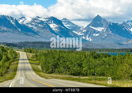 Straße in die Berge - einem bewölkten Morgen Blick auf einer kurvigen Straße (U.S. 89) in Richtung Schnee - hohe Berge im Glacier National Park begrenzt. Stockfoto