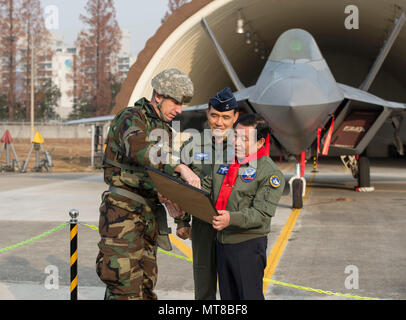 Kadena Air Base, Japan, 18 Wing Commander, Brig. Gen. Fall A. Cunningham präsentiert ein Foto zum Bürgermeister von Gwangju, Jang Hyun Yoon, vor der F-22 Raptor, Dez.07, 2017, unter Gwanju Air Base, Republik Korea. Der Bürgermeister war in der Lage, die wichtigsten Führer der Wachsam Ace Übung in Gwangju AB zu sprechen. (U.S. Air Force Foto von älteren Flieger Jessica. H. Smith) Stockfoto