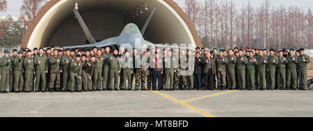 Bürgermeister der Stadt Gwangju, Jang Hyun Yoon, US Air Force Mitglieder und Kursteilnehmer und Ausbilder Piloten aus dem 1 Fighter Wing, Gwangju, posieren für ein Gruppenfoto vor der F-22 Raptor, Dez.07, 2017, in Gwangju, Korea. Der Bürgermeister war in der Lage, die wichtigsten Führer der Wachsam Ace Übung in Gwangju AB zu sprechen. (U.S. Air Force Foto von älteren Flieger Jessica. H. Smith) Stockfoto