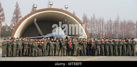 Bürgermeister der Stadt Gwangju, Jang Hyun Yoon, US Air Force Mitglieder und Kursteilnehmer und Ausbilder Piloten aus dem 1 Fighter Wing, Gwangju, posieren für ein Gruppenfoto vor der F-22 Raptor, Dez.07, 2017, in Gwangju, Korea. Der Bürgermeister war in der Lage, die wichtigsten Führer der Wachsam Ace Übung in Gwangju AB zu sprechen. (U.S. Air Force Foto von älteren Flieger Jessica. H. Smith) Stockfoto