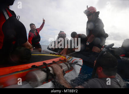 Der 'Veranda' floatation Gerät ist aufgeklappt und durch Pararescuemen und zur Bekämpfung der Rettung Offiziere aus der 103 Rescue Squadron der New York Air National Guard aufgepumpt nach einem Sprung von der Rückseite einer C-17 in den Gewässern vor der Marine Corps Base Hawaii am 5. März 2017. Die Flieger waren der Prüfung mit einem aufblasbaren Gerät wie der 'Veranda', die dazu bestimmt sind, die Orion Raumschiff gesteckt zu werden, und nach einem Flug Astronauten, die eine Wasser Landung gemacht haben, zu unterstützen. (US Air National Guard Foto: Staff Sgt. Christopher S. Muncy) Stockfoto