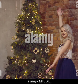 Stilvolle Frau schmücken Weihnachtsbaum. weihnachtsgrüße Konzept Stockfoto