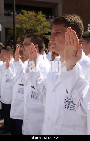 Marine Ensign Ryan Craig (rechts) rezitiert die Hippokratischen Eid als Teil der jährlichen weißen Mantel Zeremonie an der Uniformed Services Universität der Health Sciences, Bethesda, Md., 11. Mai 2018. Craig war unter den fast 170 uniformierte des ersten Jahres Medizinstudenten aus der USU F. Edward Hebert Schule von Medizin - 'America's Medical School' -, die ihre traditionellen weißen Mänteln, die den Übergang zu klinischen Service und die Versorgung der Patienten zu symbolisieren. Stockfoto