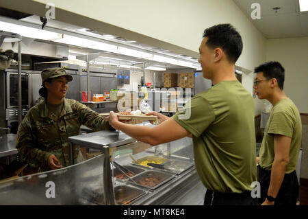 Spc. Maria Anaya, einem kulinarischen Specialist 2 Bataillon zugeordnet, 35th Infantry Regiment, 3. Brigade Combat Team, 25 Infanterie Division, Hände ein Fach zurück zu einem Singapur Armee Soldat im Speisesaal an der 298th Regiment, dokumentenportal Training (MFTU), Regional Training Institute (RTI), Kailua, Hawaii, am 15. Mai 2018. Kulinarische Spezialisten mit den 25 ID machen Chow für USA und Singapur Armee für Tiger Balm 18. (U.S. Armee Foto: Staff Sgt. Armando R. Limon, 3. Brigade Combat Team, 25 Infanterie Division). Stockfoto