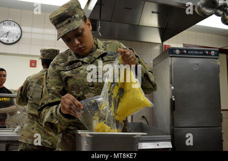 Pfc. Shanae Scott, einem kulinarischen Specialist 3 Geschwader zugewiesen sind, 4.Kavallerie Regiments, 3. Brigade Combat Team, 25 Infanterie Division, bereitet die gefriergetrockneten Eier zum Frühstück im Speisesaal an der 298th Regiment, dokumentenportal Training (MFTU), Regional Training Institute (RTI), Kailua, Hawaii, am 15. Mai 2018. Kulinarische Spezialisten mit den 25 ID machen Chow für USA und Singapur Armee für Tiger Balm 18. (U.S. Armee Foto: Staff Sgt. Armando R. Limon, 3. Brigade Combat Team, 25 Infanterie Division). Stockfoto