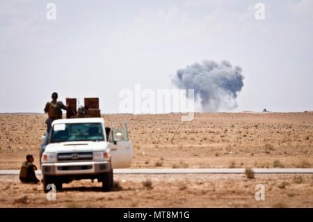 Syrisch demokratischen Kräfte beobachten, wie eine Koalition airstrike sein Ziel auf einem bekannten ISIS Lage nahe der Grenze Iraqi-Syrian Hits, 13. Mai 2018. Diese SDF Kräfte vorausgesetzt Sicherheit für eine Koalition Mörser team und wurden posierten Quick Response Force Services zu bieten, falls erforderlich. Der Streik wurde zur Unterstützung der Operation Roundup, die Offensive der letzten Taschen von ISIS aus dem nahen Fluss Euphrat Valley in Syrien zu befreien. (U.S. Armee Foto: Staff Sgt. Timothy R. Koster) Stockfoto