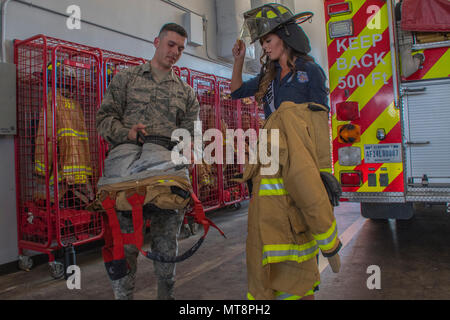 Airman 1st Class Austin Nash, ein Feuerwehrmann der Feuerwehr in Barksdale Air Force Base in Louisiana zugewiesen, zeigt Logan Lester, Fräulein Texas USA 2018, Brandbekämpfung Gang während Lester's Besuch in Barksdale mit anderen Kandidaten im Jahr 2018 Miss USA Pageant, 15. Mai 2018. Feuerwehrmänner angezeigt, Feuerlöscheinrichtungen und Feuerwehrautos während des Wettbewerbsteilnehmers tour. (U.S. Air Force Foto von Airman Maxwell Daigle/Freigegeben) Stockfoto