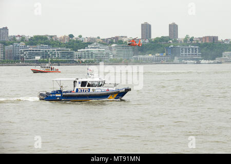 New York, NY - 28. Mai 2018: Die US-Küstenwache MH-65D Dolphin Hubschrauberbesatzung Such- und Rettungsmaßnahmen Demonstration über offenes Wasser als NYPD boot Aufenthalt guard während des Memorial Day Feier in Intrepid Sea, Air & Space Museum Credit: Lev radin/Alamy leben Nachrichten Stockfoto