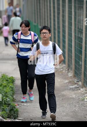 (180529) - XI'AN, 29. Mai 2018 (Xinhua) - Studenten zu Fuß in Richtung Bahnhof Baishuijiang im Nordwesten der chinesischen Provinz Guansu, 27. Mai 2018. Der Zug Nr. 6063, welche Links 38 Stationen entlang der Route von Baoji der Provinz Shaanxi und Guangyuan der Provinz Sichuan, serviert Ihnen Tausende von Studenten, die in den Bergregionen leben und müssen Pendeln von Schulen zu Hause jede Woche. Zur Verbesserung der Dienstleistungen für die Fahrgäste, Student spezielle Wagen mit größere Schreibtische installiert und eine Bibliothek wurden Ende 2017 in Betrieb genommen. Mit dem Ansatz der diesjährigen Internationalen Tag des Kindes, Stockfoto