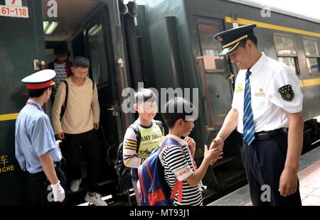 (180529) - XI'AN, 29. Mai 2018 (Xinhua) - erhalten die Schüler aus und verabschieden Sie sich von Xiang Baolin, Dirigent des Zug Nr. 6063, bei Lueyang Bahnhof im Nordwesten der chinesischen Provinz Shaanxi, 27. Mai 2018. Der Zug Nr. 6063, welche Links 38 Stationen entlang der Route von Baoji der Provinz Shaanxi und Guangyuan der Provinz Sichuan, serviert Ihnen Tausende von Studenten, die in den Bergregionen leben und müssen Pendeln von Schulen zu Hause jede Woche. Zur Verbesserung der Dienstleistungen für die Fahrgäste, Student spezielle Wagen mit größere Schreibtische installiert und eine Bibliothek wurden Ende 2017 in Betrieb genommen. Wi Stockfoto