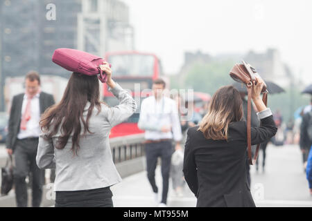 London, Großbritannien. 29. Mai 2018. Pendler, die nach der heißen Bank Holiday Wochenende Schutz unter Sonnenschirmen aus der Regen auf die Westminster Bridge Kredit zu arbeiten: Amer ghazzal/Alamy leben Nachrichten Stockfoto