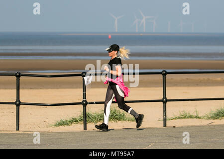 Frau, die an der Strandpromenade in Crosby, Liverpool, läuft. 29th. Mai 2018. Wetter in Großbritannien: Heller Sommertag an der Nordwestküste, da Anwohner und Urlauber am frühen Morgen auf dem Küstenpfad und dem Merseyside-Strand trainieren. Der Strand ist mit Abfall von Spring Bank Holiday mit überfließenden Mülleimern und Müll, der in der Brise weht, übersät. Der rat von Sefton hat eindeutig keine ausreichenden Kunststoffbehälter für die Menge an Kunststoffabfällen. Quelle: MediaWorldImages/AlayyLiveNews. Stockfoto