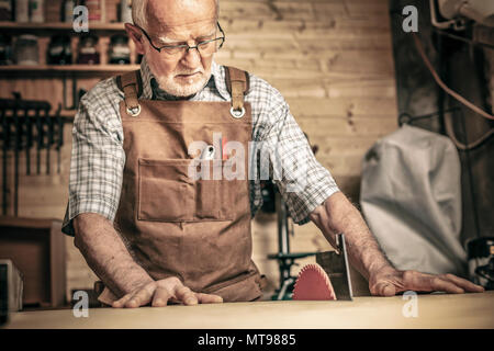 Professionelle Tischler arbeitet mit einer Säge Bank in seiner Werkstatt Stockfoto