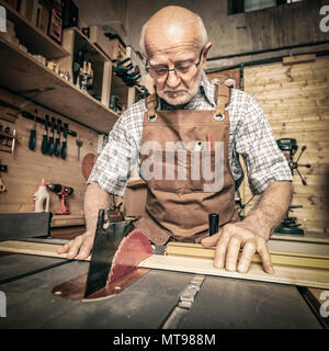 Professionelle Tischler arbeitet mit einer Säge Bank in seiner Werkstatt Stockfoto