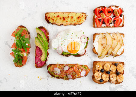 Auswahl an gesunden Frühstück Toast auf einem weißen Hintergrund im Landhausstil. Ansicht von oben, flach Stockfoto