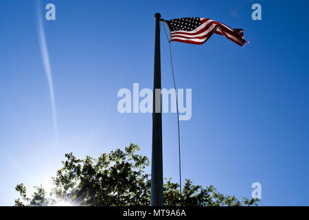 Amerikanische Flagge weht im Wind, Himmel, die mit dem Sonnenlicht hoch in den blauen Himmel. Inspirierende patriotischen Symbol für die Vereinigten Staaten. Stockfoto