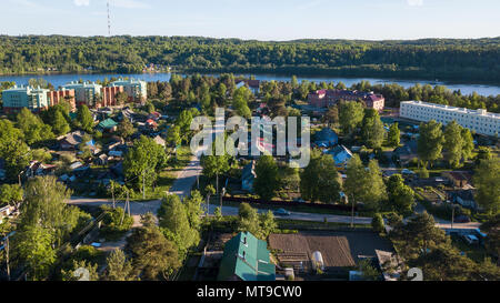 Russischen Dorf mit Holzhäusern. Fluss Svir und im Sommer grüne Wälder der Region Leningrad, Russland. Fliegen über die Dächer. Stockfoto