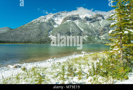 Pristine Kananaskis Country in den kanadischen Rockies. Der Schnee die Berge und Bäume am Ufer des Sees. Türkises Wasser. Blue Sky. Der erste Schnee. Stockfoto