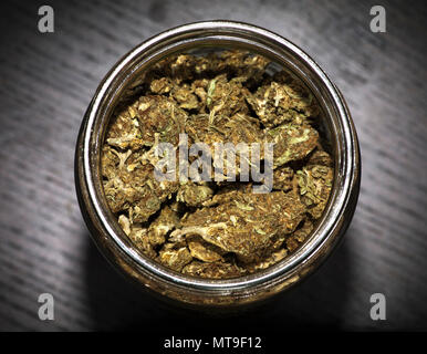 Glas Glas voller Marihuana auf Holz schwarz Tabelle Stockfoto