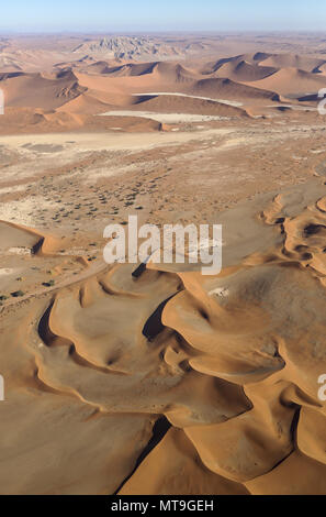 Sanddünen in der Namib Wüste. Oben in der Mitte der Witberg (Weißer Berg, 426 m), einem granitmassiv in der Mitte der Wüste Namib. Mit Camelthorn Bäume (Acacia Erioloba) bei der trockenen Bett des Tsauchab Flusses. Luftaufnahme. Namib-Naukluft-Nationalpark, Namibia. Stockfoto