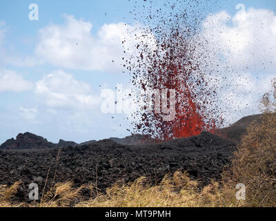 Kīlauea ist ein aktiver Schildvulkan auf Hawaii, der 2018 mehrere Eruptionsrisse hervorgerufen hat. Am 18. Mai 2018 brach bei Pahoa im Gebiet der Leilani Estates eine siebzehnte Lavaspalte aus, während eines signifikanten Vulkanausbruchs. Das Archivbild dokumentiert Lavafründungen und Notfallunterstützung, die von der Hawaii National Guard während der Evakuierung bereitgestellt werden. Stockfoto
