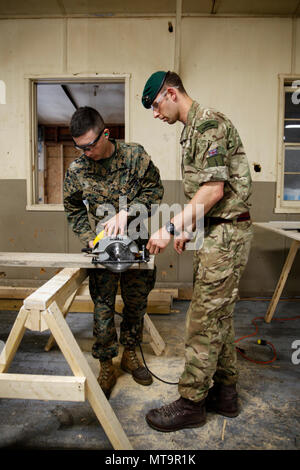 Britische Armee Spr. Mark R. Maton, Commando mit 131 Commando Squadron Royal Engineers, britische Armee, lehrt US Marine Lance Cpl. Cody A. Evans, Combat engineer mit dem Ingenieur Unternehmen C, 6 Techniker, 4. Marine Logistik Gruppe, wie eine Kreissäge Power Tool auf einer Baustelle während der Übung rote Dolch am Fort Indiantown Gap, Pa, 19. Mai 2018. Übung rote Dolch ist eine bilaterale Übung, die Marines die Möglichkeit, Taktiken, Techniken und Verfahren sowie Aufbau von Arbeitsbeziehungen mit ihren britischen Kollegen. (U.S. Marine Corp Stockfoto