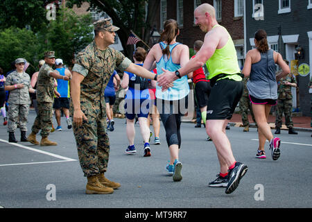 Us Marine Corps Gunnery Sgt. Rodrigo Davalos, combat Development Company Gunnery Sgt., Marine Coprs Base Quantico, high-fives ein Läufer während des 11. jährlichen Marine Corps historischen (MCHH) 13,1 - 1,6 km Lauf durch die historische Innenstadt von Fredericksburg, Virginia, 20. Mai 2018 Die MCHH lockt über 8.000 Teilnehmer und beinhaltet die Devil Dog Double und Marine Corps Semper 5ive Rennen. (U.S. Marine Corps Foto von Pfc. Quinn verletzt) Stockfoto