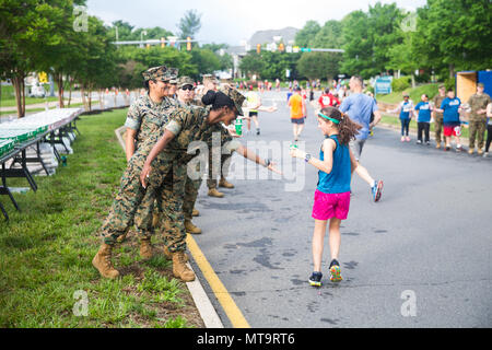 Ein US-Marine bietet Wasser zu einem Teilnehmer des 11. jährlichen Marine Corps historischen (MCHH) laufen in Fredericksburg, Virginia, 20. Mai 2018. Die MCHH lockt über 8.000 Teilnehmer und beinhaltet die Devil Dog Double und Marine Corps Semper 5ive Rennen. (U.S. Marine Corps Foto von Pfc. Yuritzy Gomez) Stockfoto