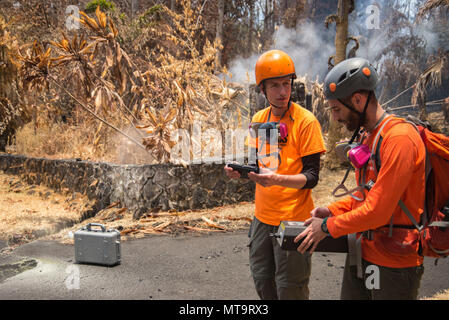 Pāhoa, Hawaii, 19. Mai 2018 - U.S. Geological Survey (USGS) Forschung Wissenschaftler Christoph Kern (links) und USGS freiwillige Allen Lerner (rechts) Verwendung von Schwefeldioxid (SO2) Sensoren für die Luftqualität zu prüfen, nachdem das Kīlauea Vulkanausbruch. Die Wohngegend von Leilani Estates hat sich aufgrund der hohen Konzentration von SO2-Emissionen aus der Risse in die Erde, dass Lava in den Unterteilungen verschüttete evakuiert worden. Auf Ersuchen des Staates, FEMA-Mitarbeiter sind im lokalen Beamten mit Leben zu unterstützen platzsparende Not-aus Schutzmaßnahmen, Fremdkörper entfernen, und die Reparatur, Austausch oder restorati Stockfoto