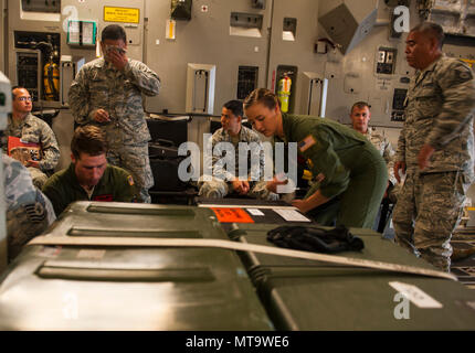 Airman 1st Class Trenton Turner und Senior Airman Korina Myers, loadmasters der 535th Airlift Squadron zugeordnet, sichern die Ladung in einer C-17 Globemaster III während der Übung Tropic Thunder 2017 (Xtt 17), Joint Base Pearl Harbor-Hickam, Virginia, 19. April 2017. XTT17 ist Teil Zwei volle Spektrum Bereitschaft Übung bewirtet durch die 15 Flügel der individuellen, der organisatorischen und der expeditionary Bereitschaft der Flieger auf Hickam Field stationiert zu testen. Stockfoto