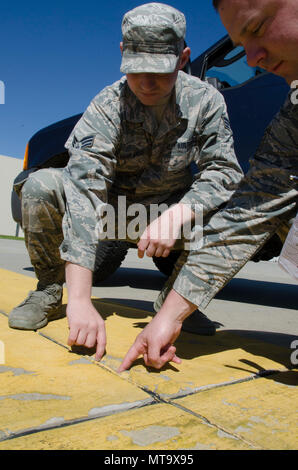 SrA Mike Vasilakos Engineering Assistant, 108 Bauingenieur Geschwader, und Tech. Sgt. Sean Joseph, Operations Manager, 108 Bauingenieur Squadron, Prüfen und Dokumentieren einen Riss in der Zement der 108 Flugzeuge parken Rampe, ohne ordnungsgemäße Wartung hat das Potenzial zu erstellen FOD (Foreign Object Ablagerungen) und ein Flugzeug beschädigt werden. Stockfoto