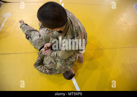 Us-Armee Sgt. Christopher Nathan, simuliert cuffing auf SPC. Jakob Ruth, während der Gemeinsame taktische Combatives Course, auf chièvres Air Base, Belgien, 9. März 2018. Nathan und Ruth sind mit der US-Armee Netzwerk Enterprise Center Beglium, 39 strategisches Signal Battalion. Stockfoto