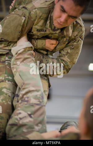 Us-Armee Sgt. Christopher Nathan, führt einen Leg Lock auf SPC. Jakob Ruth, bei einer gemeinsamen taktischen Combatives Course, auf chièvres Air Base, Belgien, März 9, 2018. Nathan und Ruth sind mit der US-Armee Netzwerk Enterprise Center Belgien, 39 strategisches Signal Battalion. Stockfoto