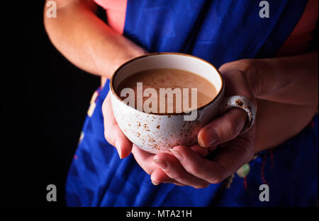 Frau im Sari Holding eine Tasse Masala Chai Tee Stockfoto