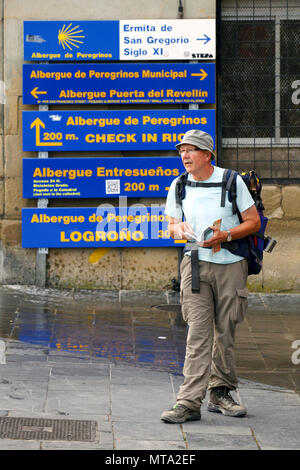 Pilger auf der Suche nach Anleitungen bei direktionalen Hinweistafeln für Hostels, Camino de Santiago, Logroño, La Rioja, Spanien Stockfoto