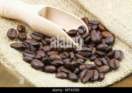 Geröstete Kaffeebohnen auf hölzernen Lufthutze und Jute Tasche Stockfoto