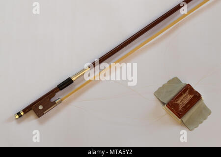 Violine Bogen und Kolophonium Fall im Bug Haar anzuwenden. Materialien für string Musikinstrument auf weißem Hintergrund. Stockfoto