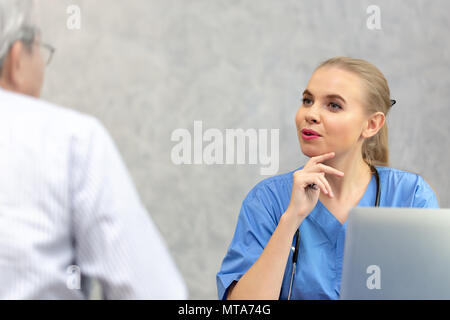 Weibliche Arzt, eine Konsultation zu ihren männlichen Patienten und erläutert medizinische Informationen und Diagnose in der Klinik oder im Krankenhaus. Stockfoto