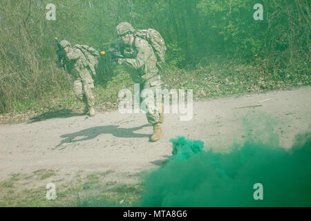 Spc. Bruno Hernandez, ein Bewohner von Oklahoma City, und SPC. Phillip Knop, auch von Oklahoma City, die durch Rauch, während ein Ziel anzugreifen, während ein situationstraining Übung während der 7. Armee Traning Befehl Noncommissioned Officer Academy Basic-Kurs an der Yavoriv Combat Training Center auf dem internationalen Friedens und der Sicherheit, in der Nähe der Yavoriv, der Ukraine, der am 20. April. Hernandez und Knop sind beide Mitglieder der 45th Infantry Brigade Combat Team eingesetzt in die Ukraine zur Unterstützung der Gemeinsamen multinationalen Ausbildung Gruppe - Ukraine. ( Stockfoto