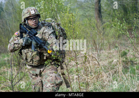 Spc. Jimmy Hill, ein Bewohner von Oklahoma City und Mitglied der 45th Infantry Brigade Combat Team in die Ukraine entsandt, sucht Gegner Rollenspieler während einer situativen Übung als Teil der 7. Armee Traning Befehl Noncommissioned Officer Academy Academy Basic-Kurs an der Yavoriv Combat Training Center auf dem internationalen Friedens und der Sicherheit, in der Nähe der Yavoriv, Ukraine statt, am 20. April. ( Stockfoto