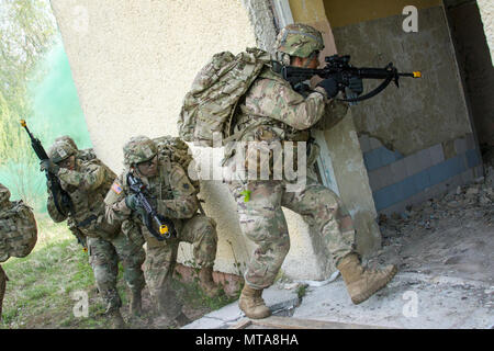 Spc. Christopher Moreno, ein Bewohner von Ames, Oklahoma Mitglied der 45th Infantry Brigade Combat Team in die Ukraine entsandt, Gebühren durch eine Tür während Angreifen eines Gebäudes als Teil einer situativen Übung während der 7th Army Traning Befehl Noncommissioned Officer Academy Basic-Kurs an der Yavoriv Combat Training Center auf dem internationalen Friedens und der Sicherheit, in der Nähe der Yavoriv, der Ukraine, der am 20. April. ( Stockfoto