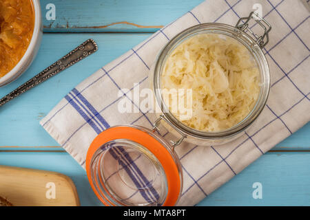 Tschechische Küche sauerkraut Suppe mit Wurst und Kartoffeln in Weiß auf Blau Holz Tisch Stockfoto