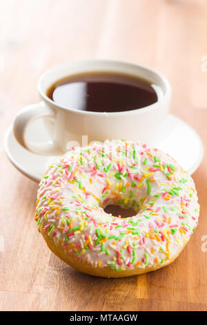 Süße Krapfen und Tasse Tee auf Holztisch. Stockfoto