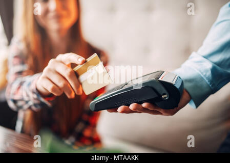 Junge Frau Zahlung mit Kreditkarte im Cafe, Kellner hand mit Terminal. Moderne Technologien im Zahlungsverkehr Stockfoto