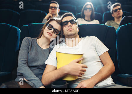 Junger Mann mit Popcorn im Kino. Langweilig film Konzept, Leute beobachten Film Stockfoto