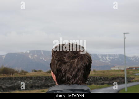 Touristische im Alter zwischen 20 und 25 stellt sich vor einer bergigen Region in Reykjavik Island Stockfoto