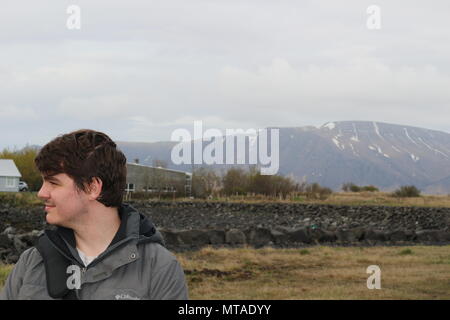 Touristische im Alter zwischen 20 und 25 stellt sich vor einer bergigen Region in Reykjavik Island Stockfoto