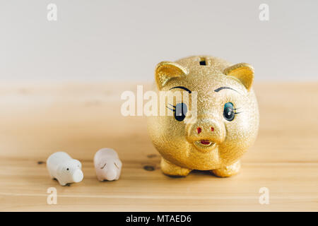 Goldene Sparschwein auf hölzernen Schreibtisch Stockfoto