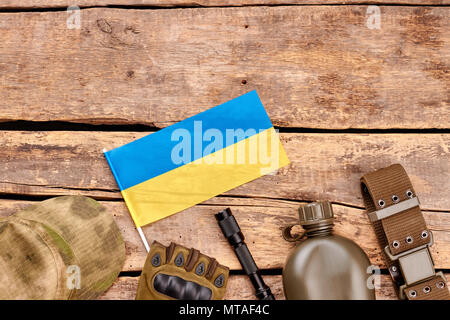 Zubehör der ukrainischen Armee Soldaten. Flach, Ansicht von oben. Schreibtisch aus Holz Tisch mit Copyspace. Stockfoto