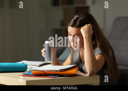 Schüler Vorbereitung Prüfung auswendig Noten halten und Energy Drink in der Nacht zu Hause Stockfoto